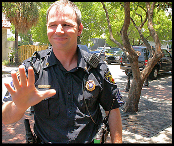 A cop stops photographers in downtown Fort Lauderdale.