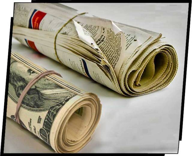 Rolled-up newspaper and rolls of bills